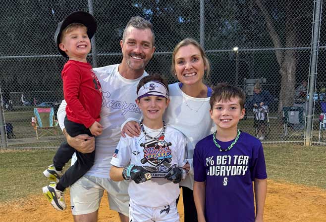 Brittany posing with her family after a little league baseball game