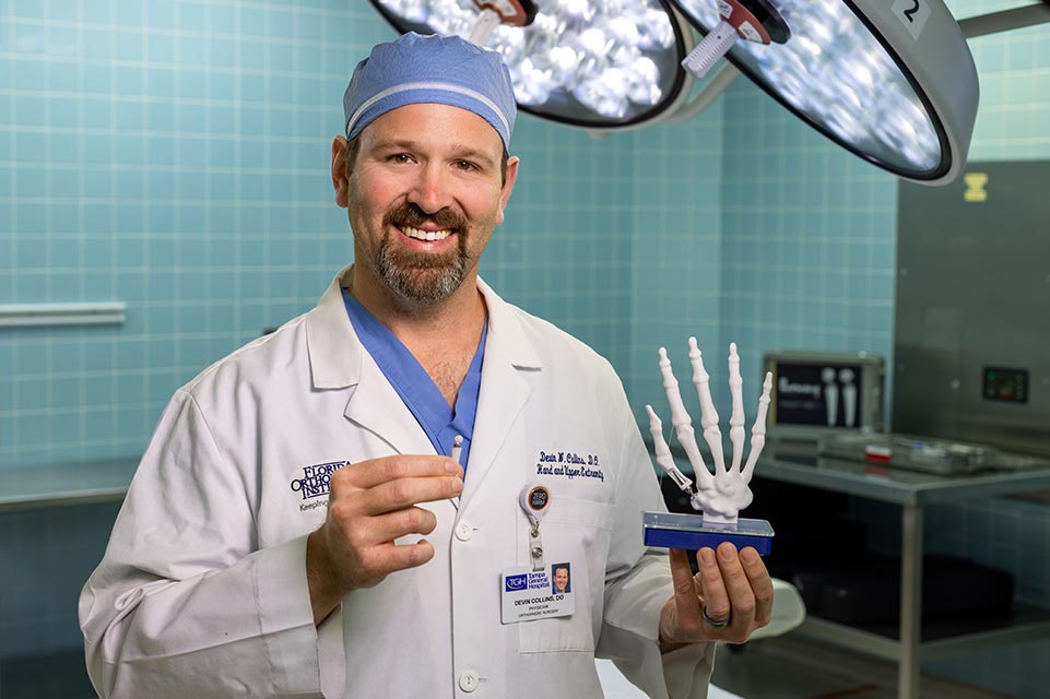 Dr. Collins stands with the new TOUCH CMC prosthesis.