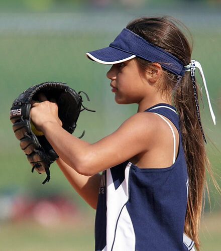 girl playing softball with mitt in hand