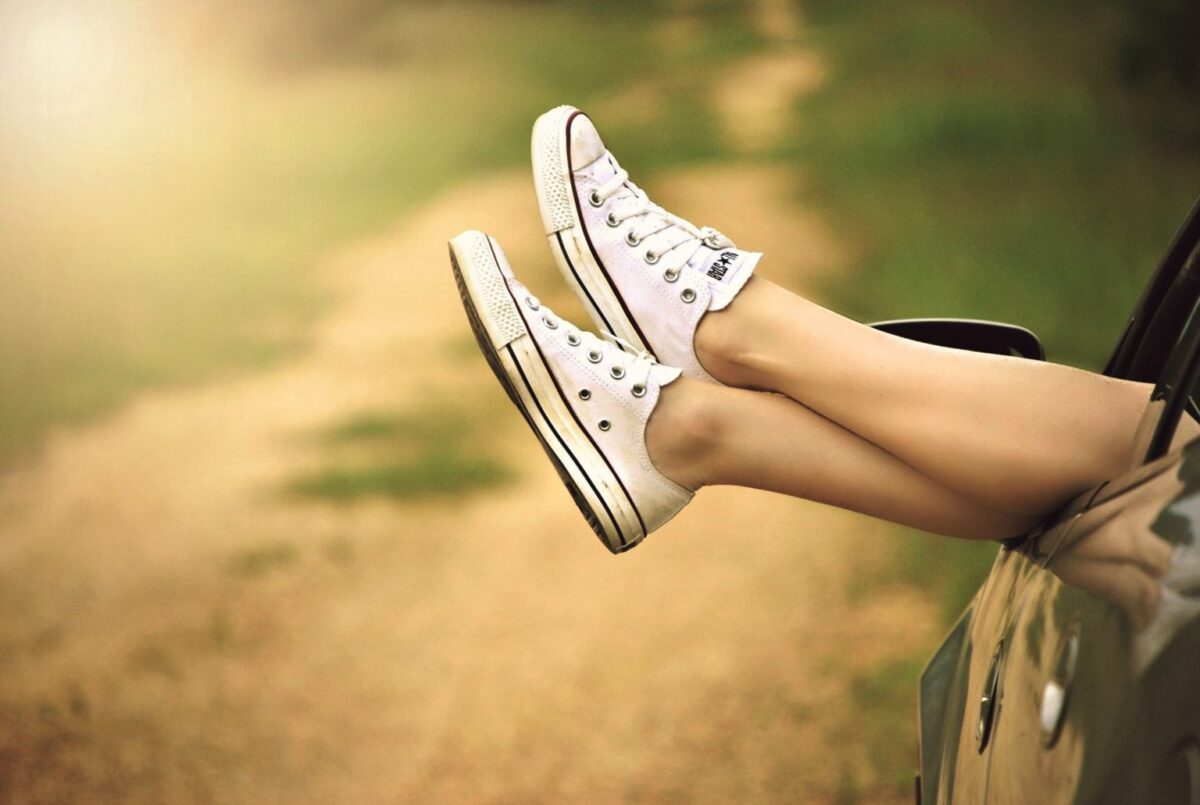 cropped photo of legs crossed wearing sneakers