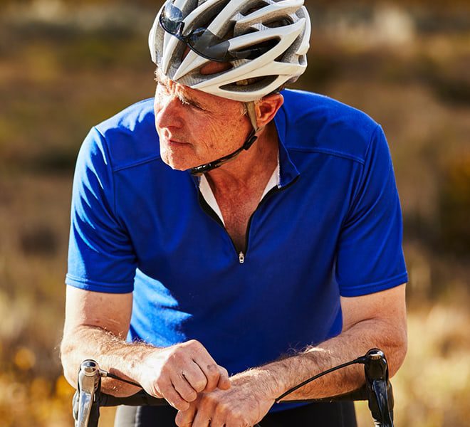 Older man in a helmet on a bicycle