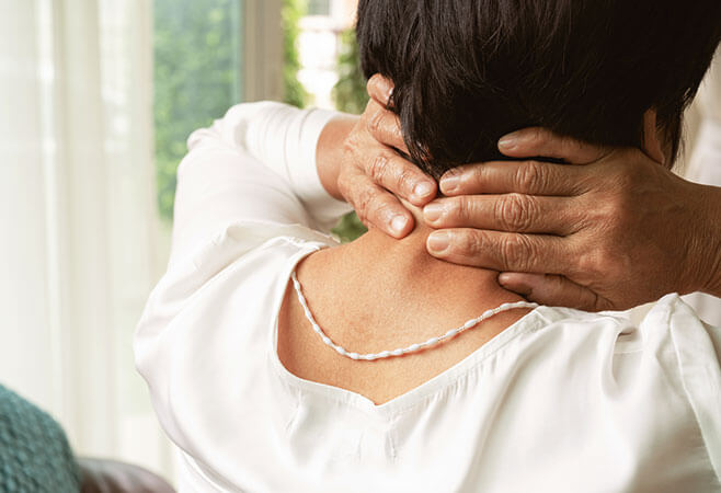Closeup of old woman suffering from neck pain, possibly a pinched nerve