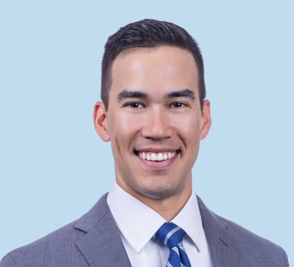 Dr. Carson Smith professional headshot, wearing grey suit and blue striped tie.