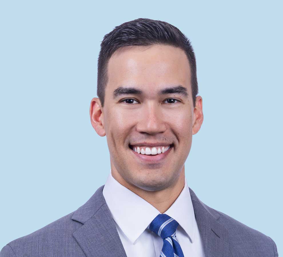 Dr. Carson Smith professional headshot, wearing grey suit and blue striped tie.