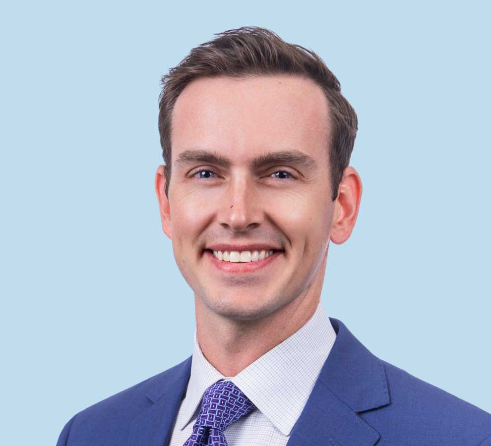 Dr. Gregory Heigle professional headshot wearing blue suit with dark blue tie