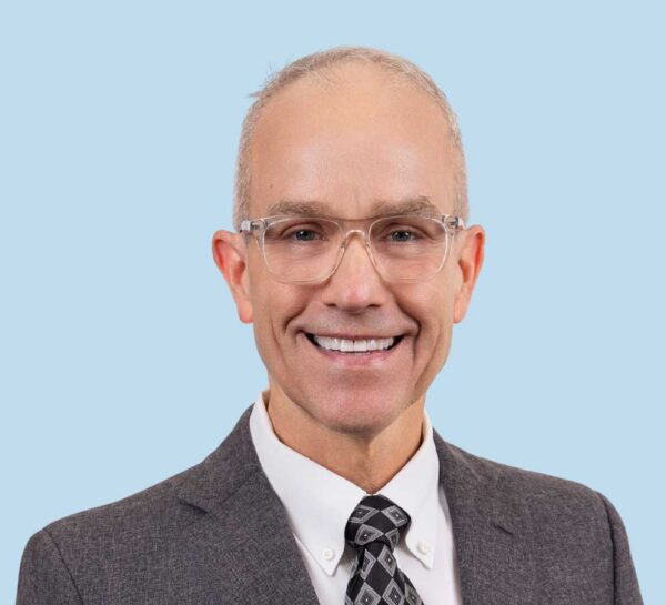 Dr. Small headshot wearing dark gray suit and tie