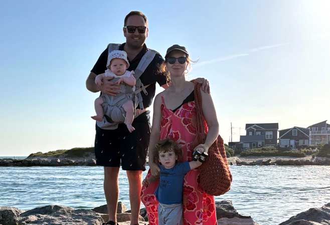 Dr. Demby and family standing in front of seascape