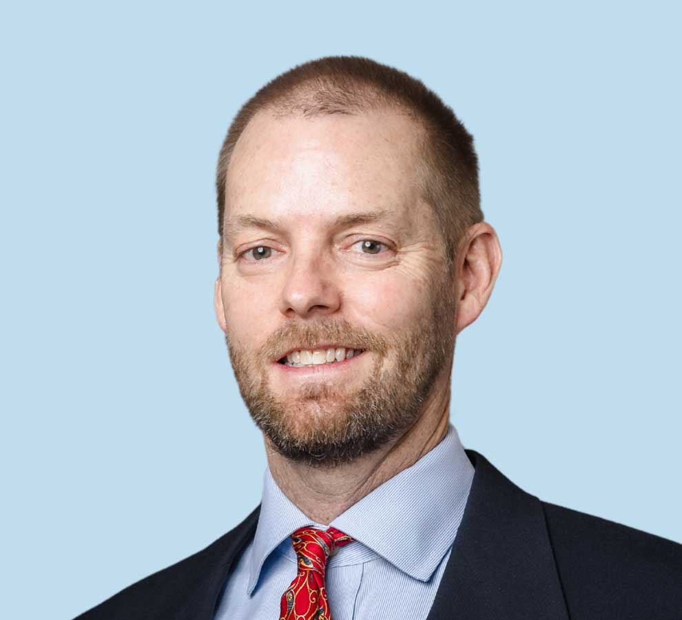 Robert C. Matthias, MD professional headshot wearing black suit and red paisley tie