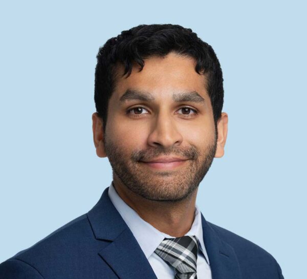 Dr. Ronit Shaw professoinal headshot wearing dark blue suit jacket and tie